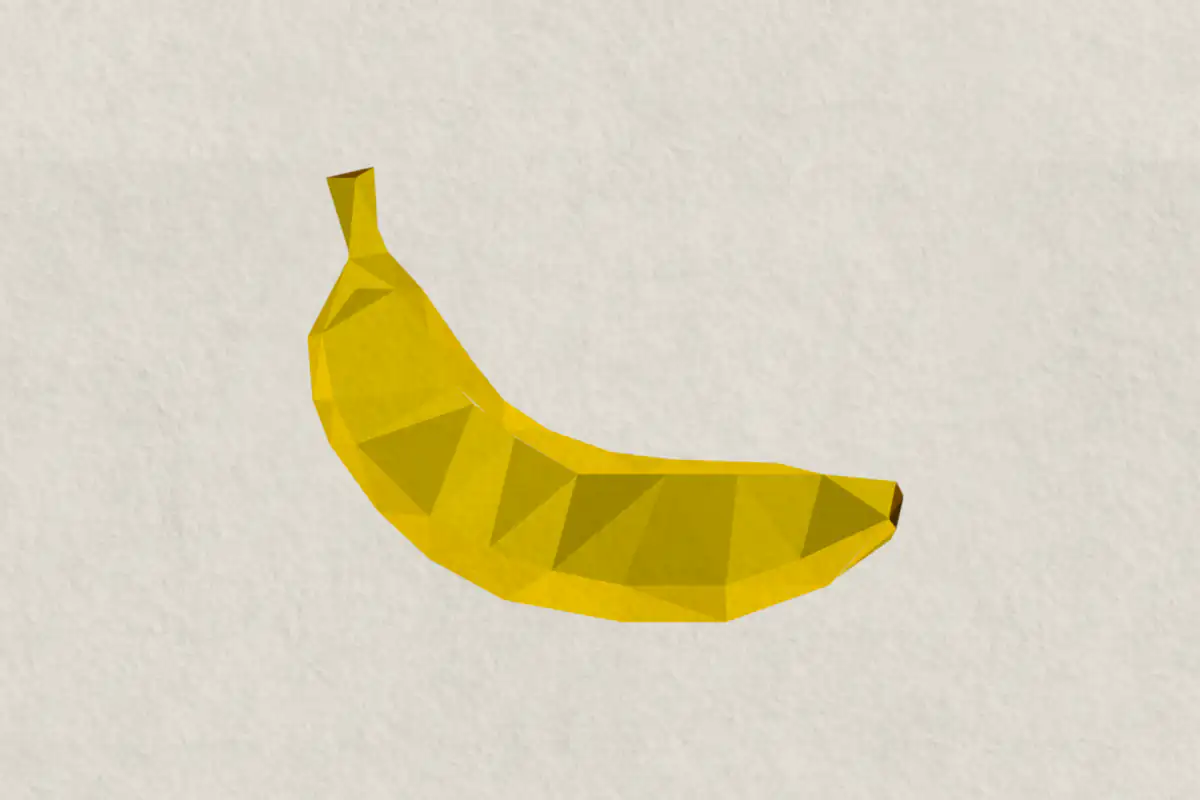 Faceted yellow banana made of flat triangles in different shades, with a brown stem end